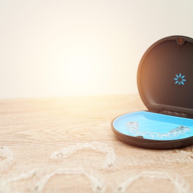 invisalign is invisible transparent aligners , clear-plastic retainers in blue box. With copyspace